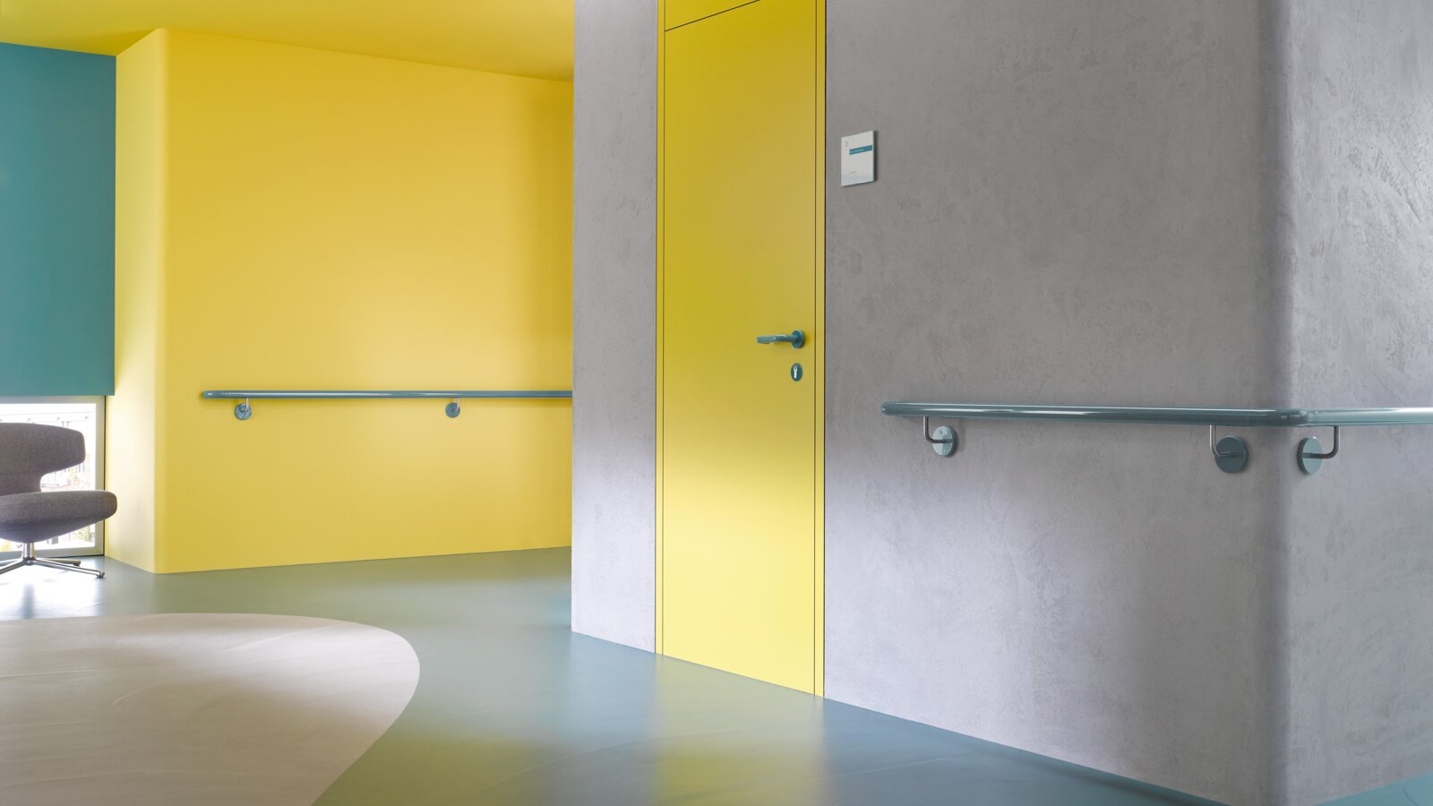 Corridor in a care building equipped with handrails in the colour aqua blue